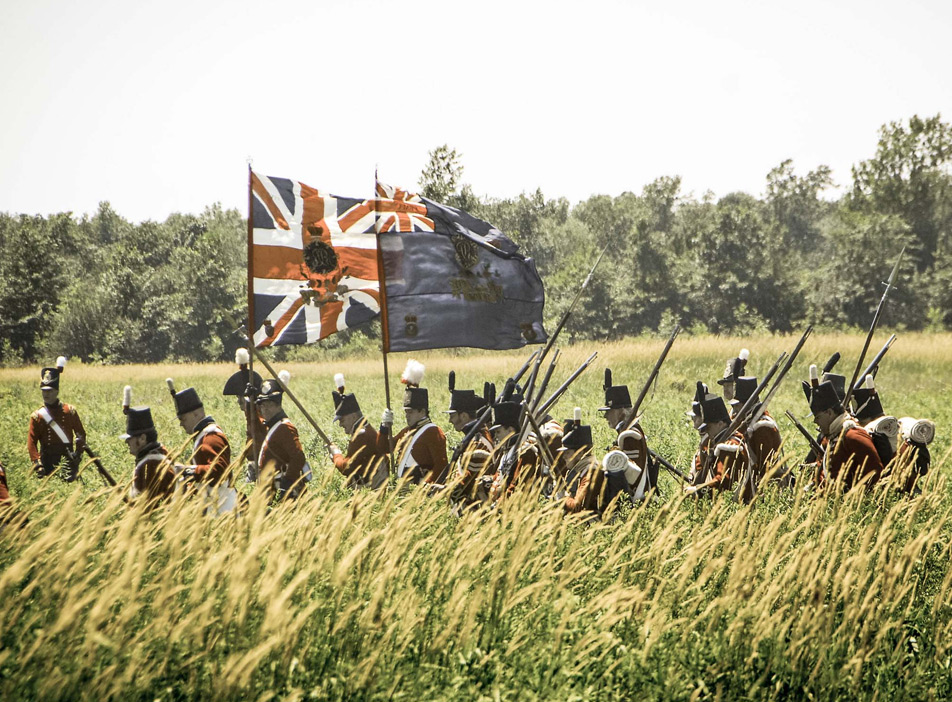 Multiple soldiers walking holding the British Flag