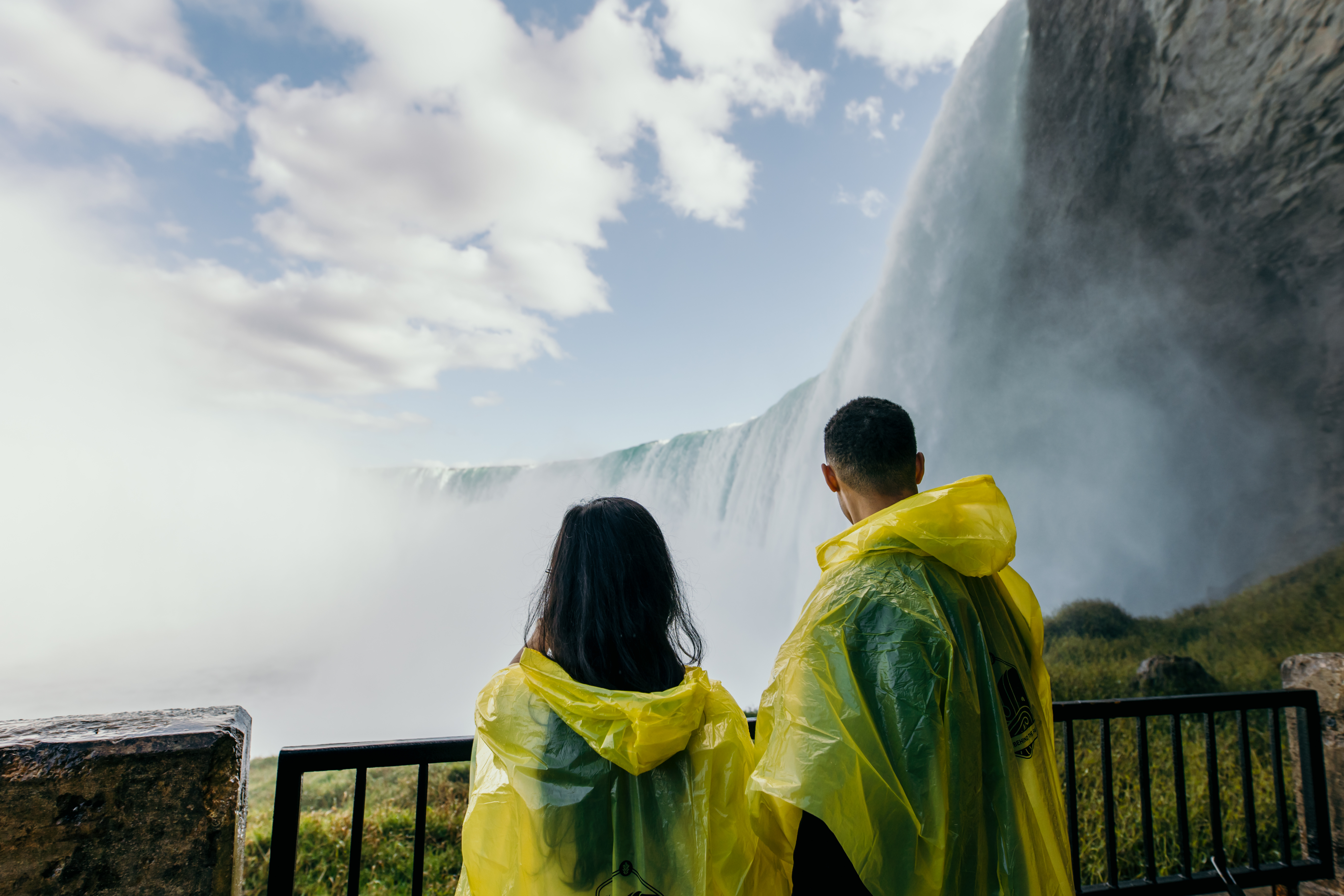 people in bluer raincoats watching 4-D movie on large screen
