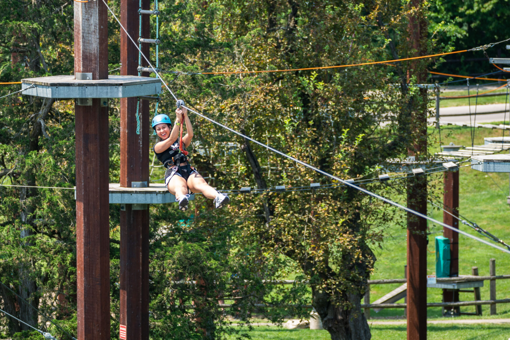 A woman sliding down the zipline high in the air